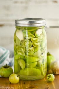 mason jar of pickled green cherry tomatoes and larger tomatoes