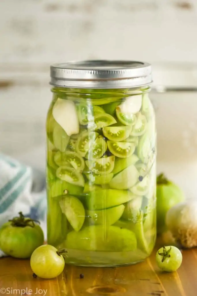 mason jar of pickled green cherry tomatoes and larger tomatoes