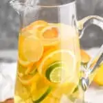 tall pitcher full of sangria with lemons, limes, and oranges