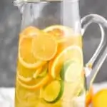 tall pitcher full of sangria with lemons, limes, and oranges