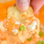 a cracker that has dipped into buffalo chicken dip