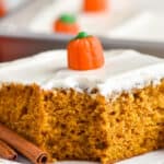 close up picture of a pumpkin cake with cream cheese frosting with a bite missing