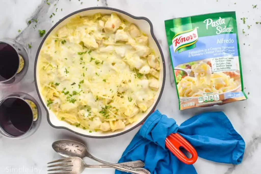 overhead of a skillet full of chicken casserole next to a package of Knorr Alfredo pasta sides