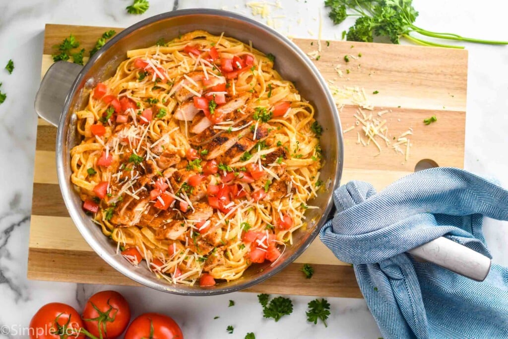 skillet full of Cajun Chicken Pasta Alfredo on a cutting board