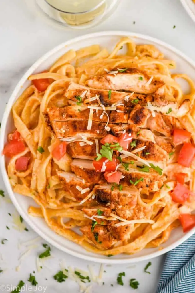 overhead of a small white plate full of cajun chicken Alfredo