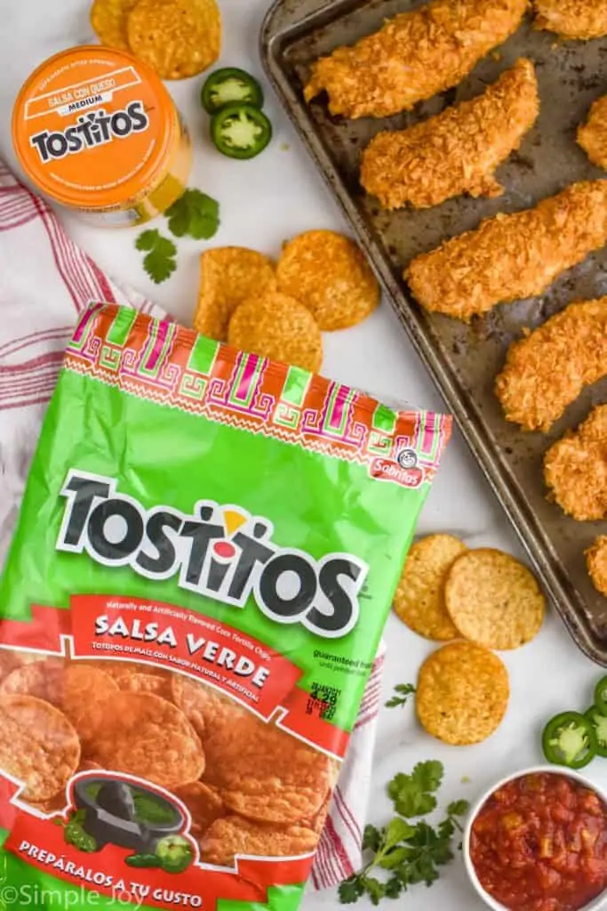 a bag of salsa verde Tostitos next to a tray fo baked chicken tenders