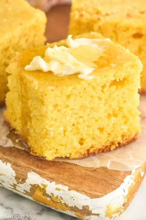 close up picture of cornbread recipe topped with butter and honey