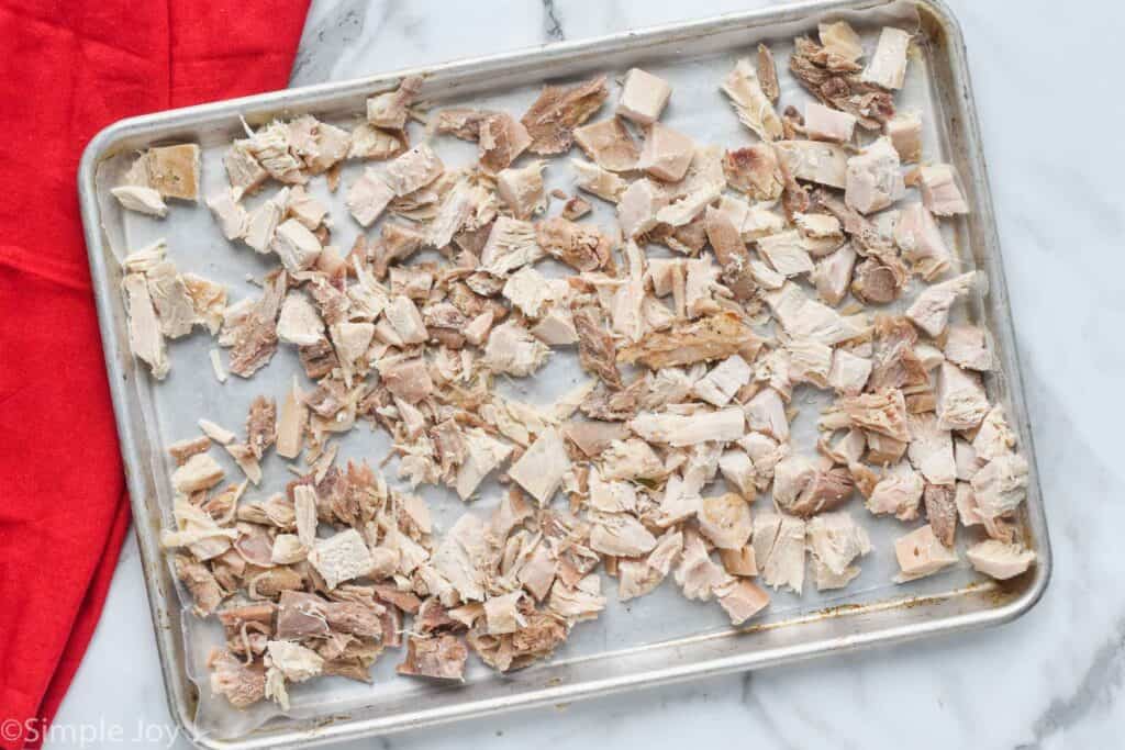 a rimmed baking sheet lined with parchment paper with bite sized pieces of frozen turkey