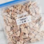 a plastic storage bag full of frozen turkey cut into bite sized pieces