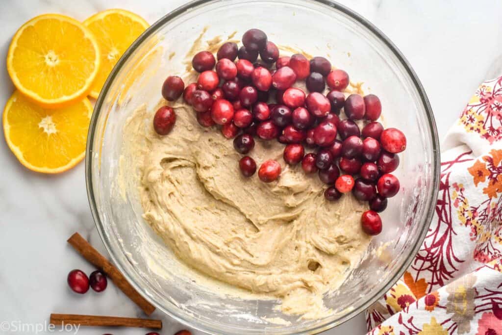 overhead view of a bowl of batter for cranberry orange coffee cake with the fresh cranberries on top