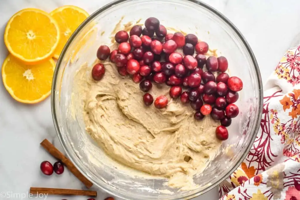 overhead view of a bowl of batter for cranberry orange coffee cake with the fresh cranberries on top