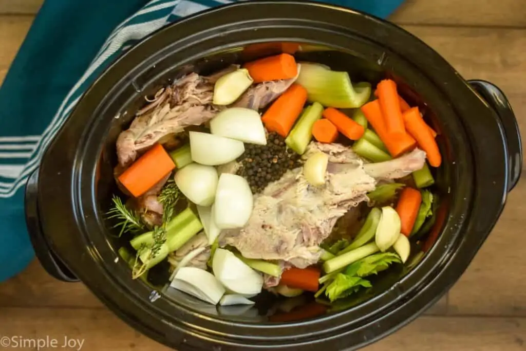 overhead view of crockpot full of ingredients for turkey bone broth