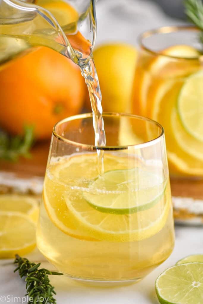 white sangria being poured into a small wine glass