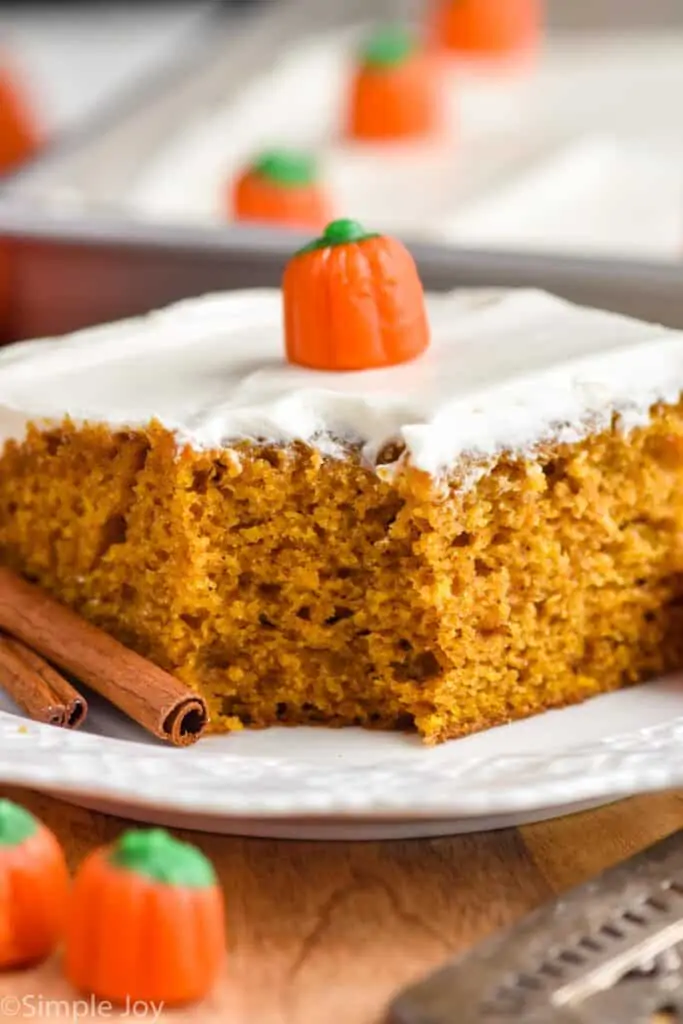 close up picture of a pumpkin cake with cream cheese frosting with a bite missing