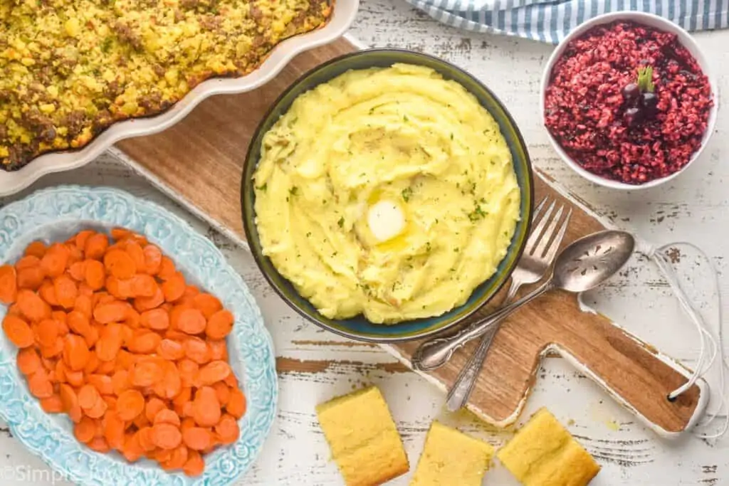 overhead view of a table full of side dish recipes, like stuffing, mashed potatoes, cranberry relish, and carrots