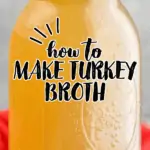 a mason jar full of turkey broth on a cutting board surrounded by fresh herbs