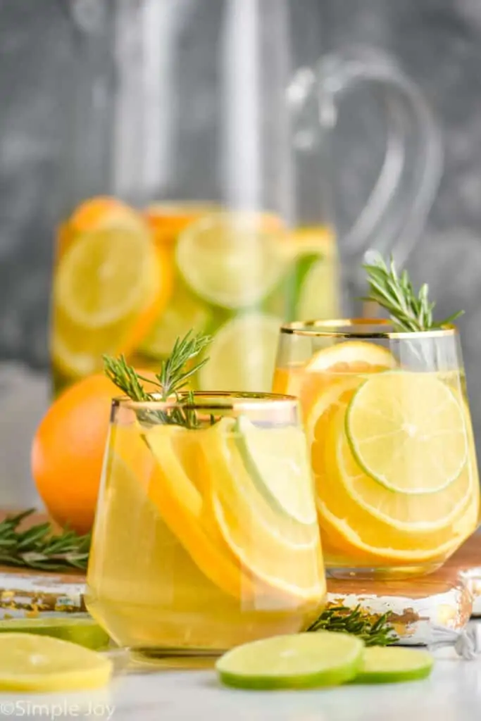 two glasses of white sangria recipe with the pitcher in the background