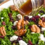 image of kale salad dressing being poured onto salad