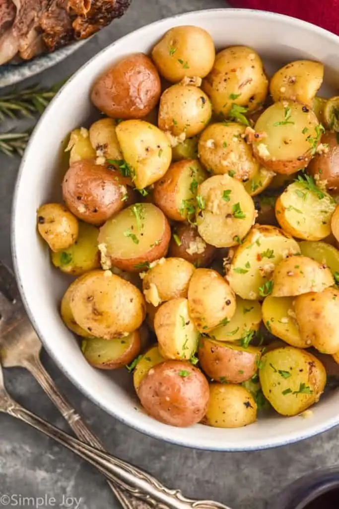 close up overhead picture of baby potatoes in a serving bowl, garnished with parsley