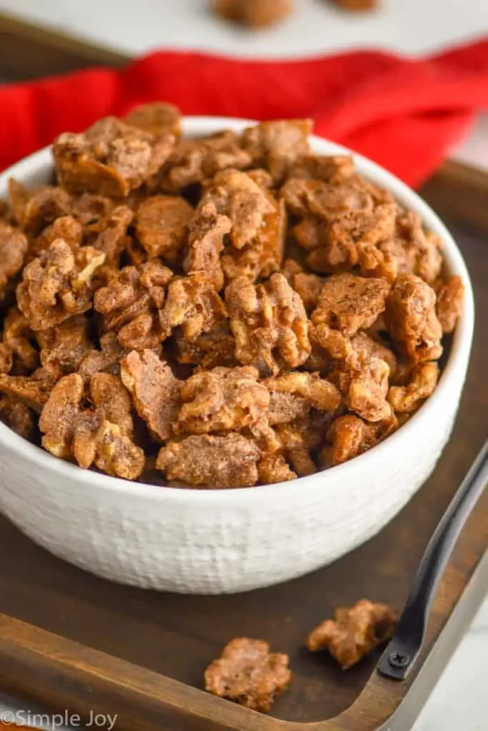 side view of candied walnuts in a white bowl