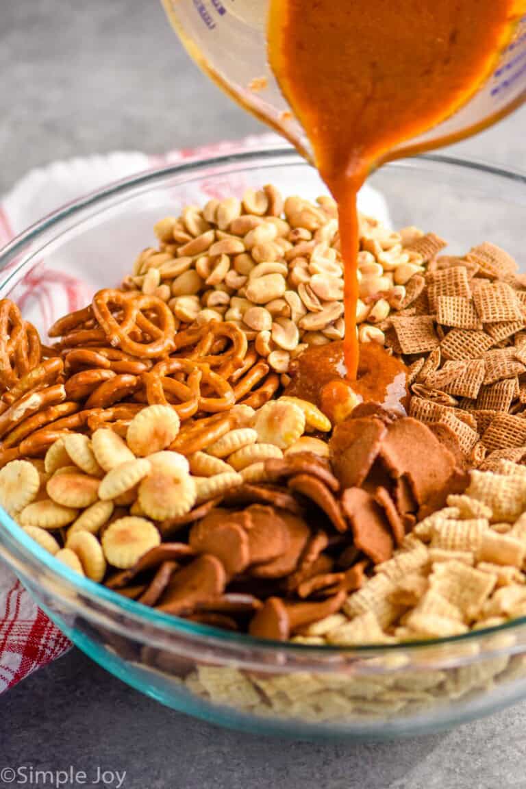 Chex mix seasoning being poured over the ingredients