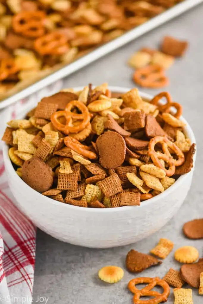 big white bowl of Chex mix with the baking sheet in the background