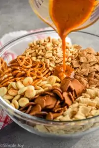 Chex mix seasoning being poured over the ingredients