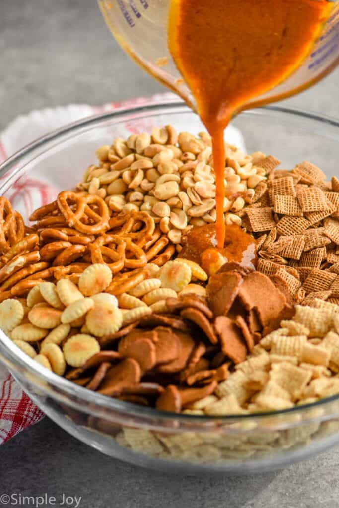 Chex mix seasoning being poured over the ingredients