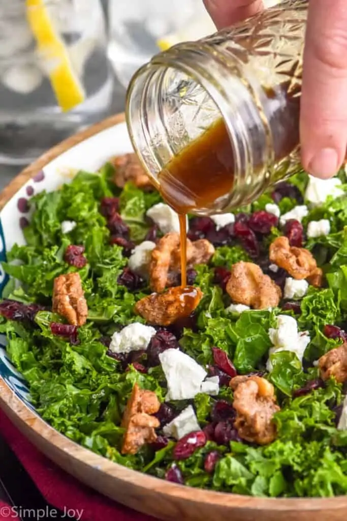 image of kale salad dressing being poured onto salad