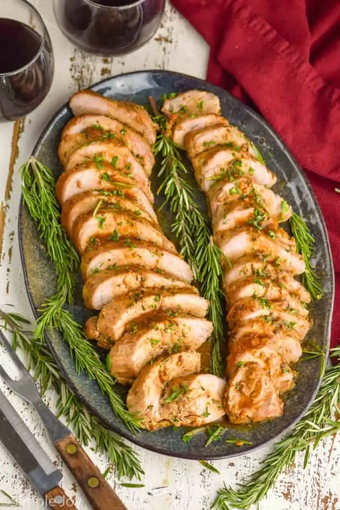 pork tenderloin cooked, cut up and garnished on a serving platter