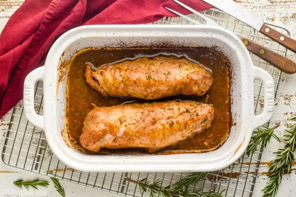 overhead image of pork tenderloin in a baking dish that has been marinated and roasted din the oven