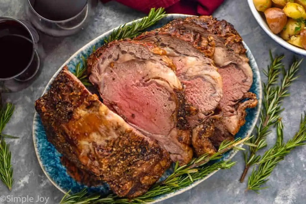 overhead of a prime rib roast on a platter that has been sliced into