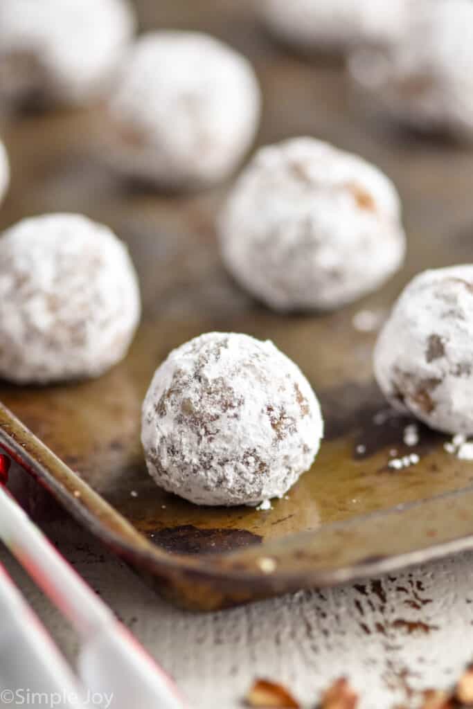 close up of a rum ball that's been rolled in powdered sugar on a baking sheet