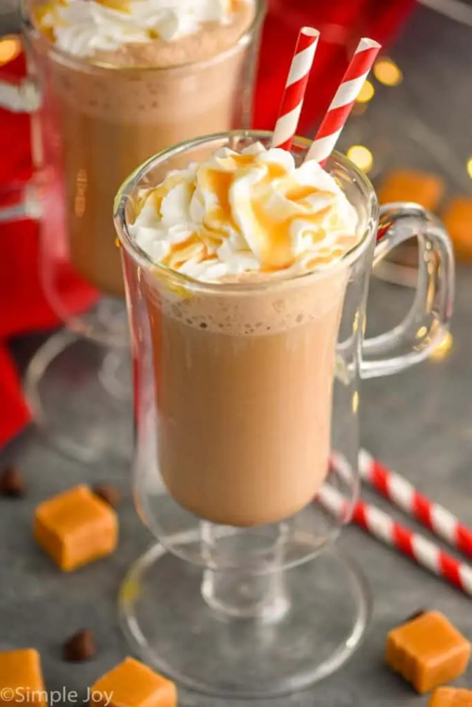 two glasses of salted caramel mocha with whipped cream and caramel topping, two straws sticking out