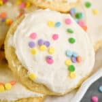 close up of a sour cream cookie on a plate that has been frosted and decorated with sprinkles