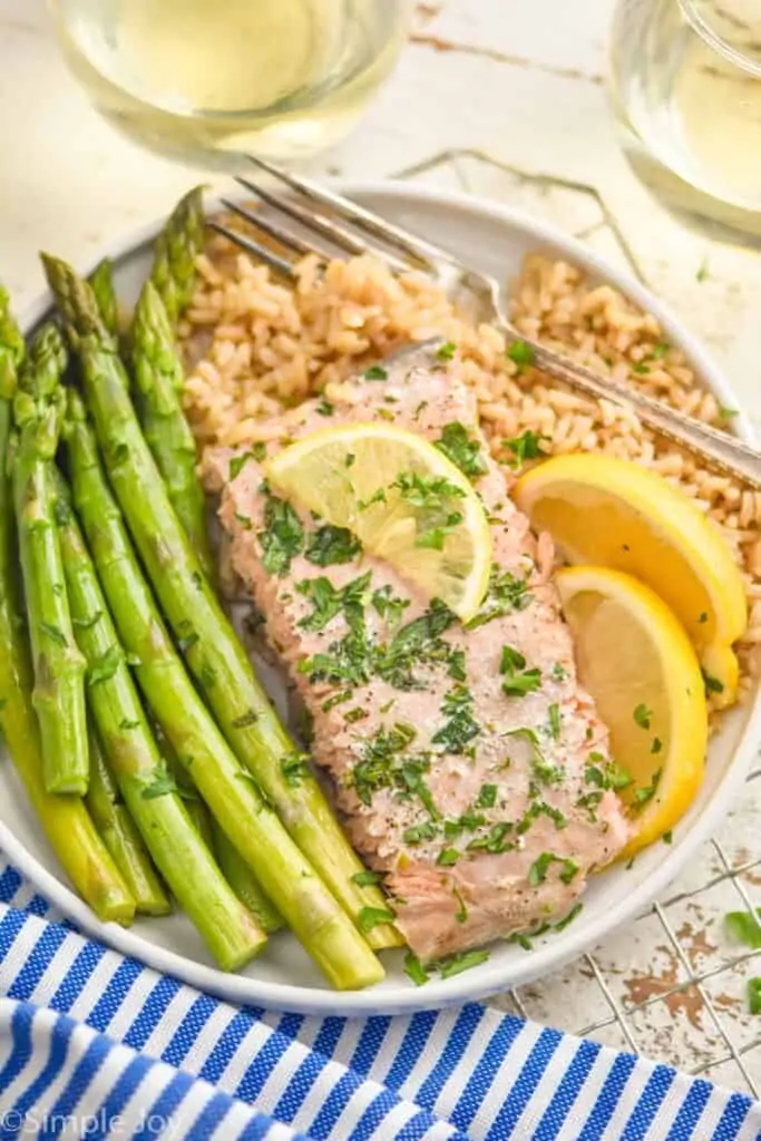 a baked salmon filet on a plate with asparagus and brown rice
