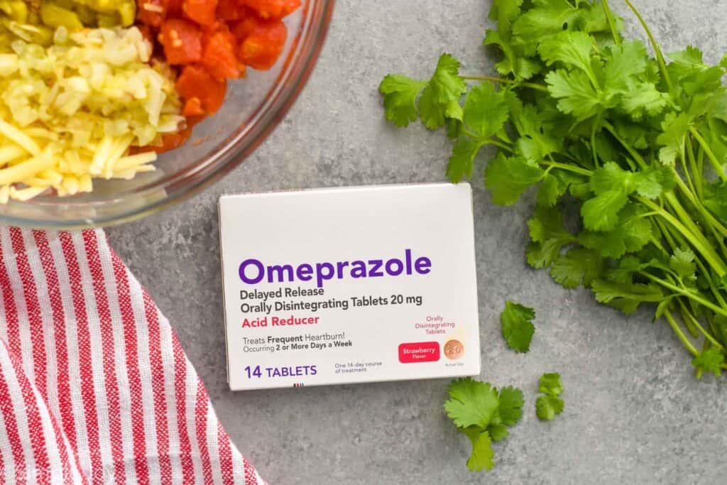 overhead photo of a box of omprezole odd next to a bunch of fresh cilantro