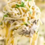 chicken tetrazzini being served up with a scoop, creamy noodles dangling down