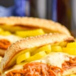 Pinterest graphic of slow cooker buffalo chicken showing a sandwich on a cutting board