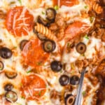 pinterest graphic showing overhead photo of a pizza casserole in a skillet with a serving spoon