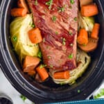 pinterest graphic of overhead photo of corned beef recipe with cabbage, carrots, and potatoes in a crockpot