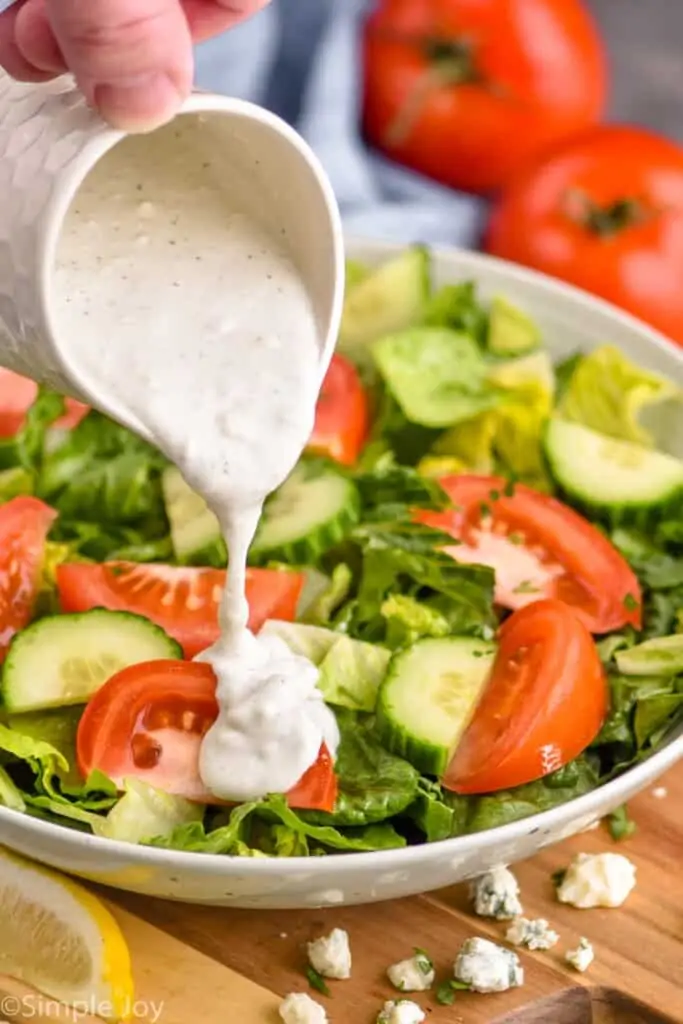 best blue cheese dressing being poured onto a salad