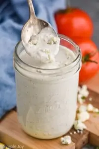 spoon pulling out a scoop of blue cheese with blue cheese crumbles on the spoon