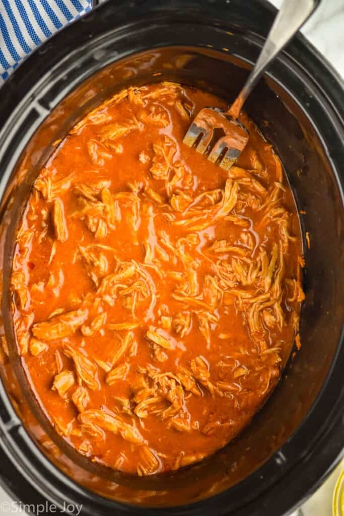 overhead of a slow cooker full of buffalo chicken