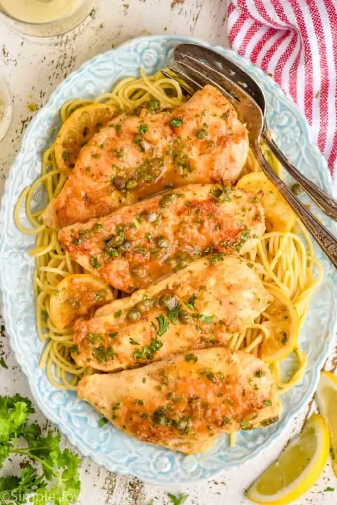 overhead view of a platter full of spaghetti and chicken piccata