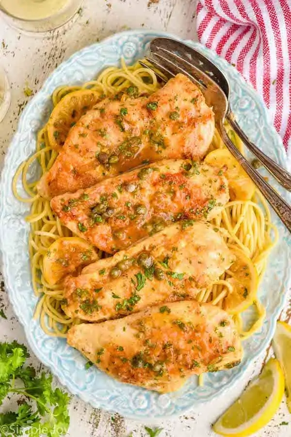 overhead view of a platter full of spaghetti and chicken piccata