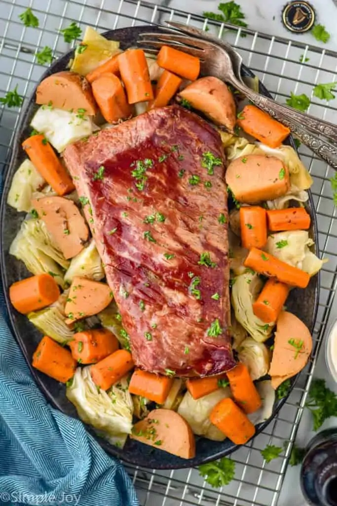 overhead of corned beef on a platter with carrots, potatoes, and cabbage