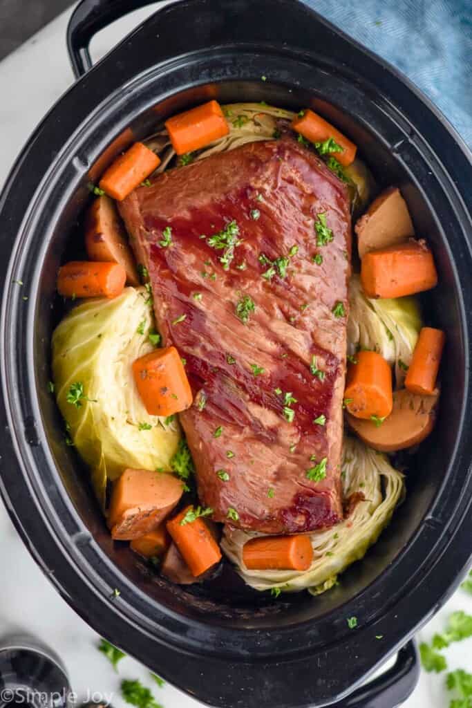overhead photo of corned beef recipe with cabbage, carrots, and potatoes in a crockpot
