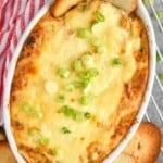 overhead view of crab dip recipe in a white casserole dish with two bagel chips sticking out of it - 13