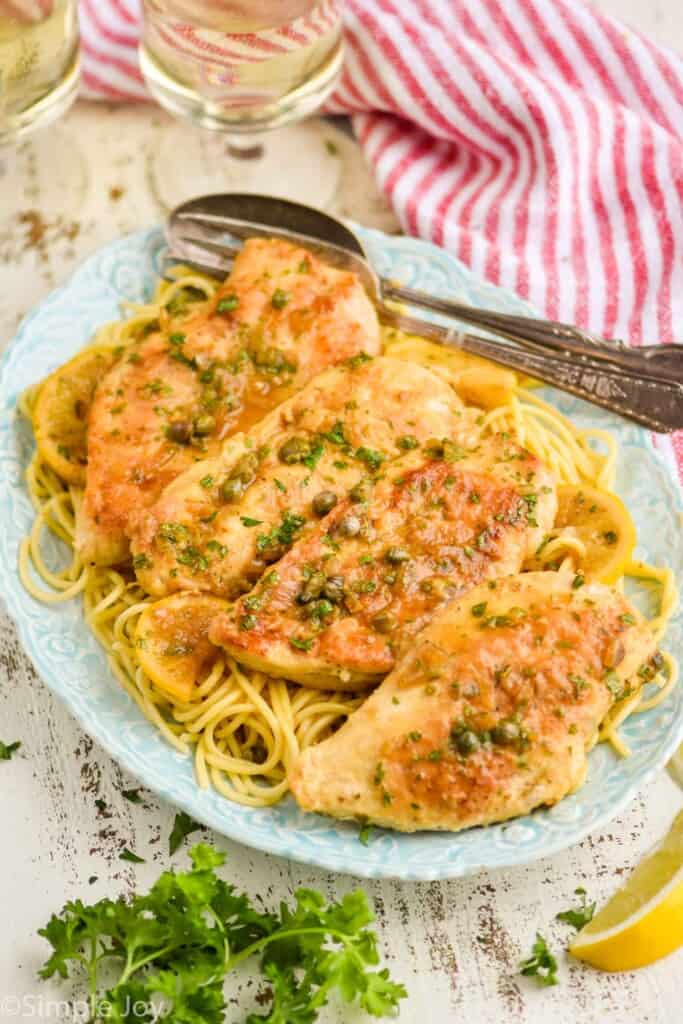 side view of a platter full of spaghetti and toped with chicken piccata recipe